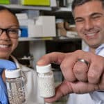 Amanda Nash y Omid Veiseh, muestran sus perlas de medicamento contra el cáncer. Foto cortesía Jeff Fitlow, Universidad Rice.