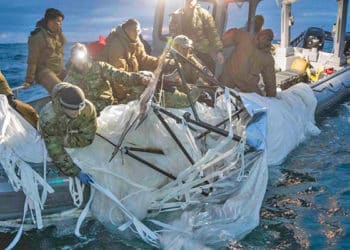 Personal militar rescata de las agua los restos del globo espía chino derribado.