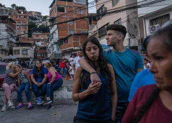Varias personas esperaban en el exterior de un colegio electoral el anuncio de los resultados de las elecciones celebradas el domingo en Caracas, capital de Venezuela.