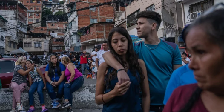 Varias personas esperaban en el exterior de un colegio electoral el anuncio de los resultados de las elecciones celebradas el domingo en Caracas, capital de Venezuela.