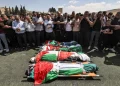 Los dolientes rezan junto a los cuerpos de cuatro hombres que murieron en una operación militar israelí, envueltos en banderas palestinas, durante su funeral en el campamento de Fara para refugiados palestinos cerca de Tubas, en el norte de la Cisjordania ocupada, el 29 de agosto de 2024.
